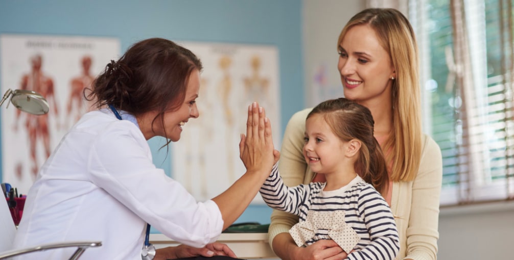 Lekarz pediatra i zadowolone z wizyty dziecko z rodzicem