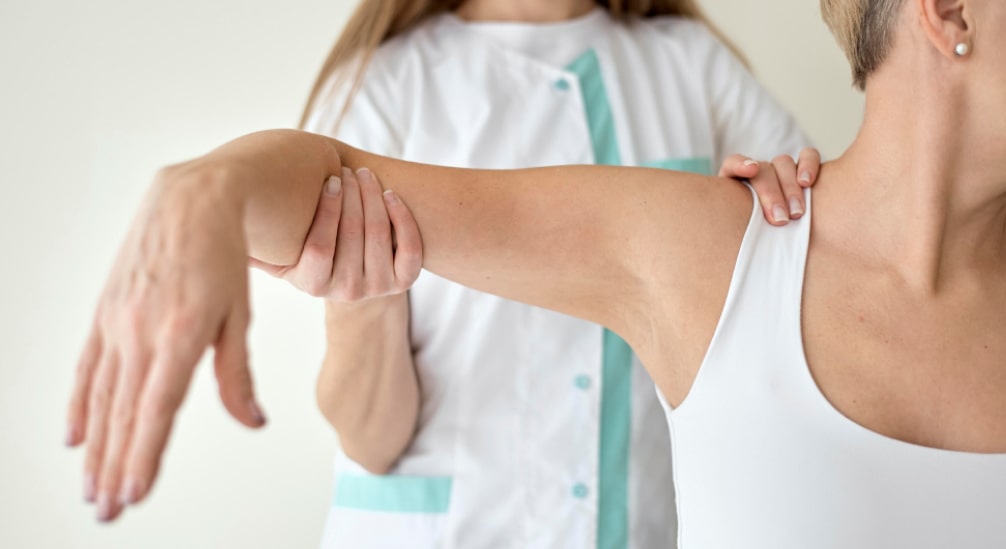 Fizjoterapeuta rehabilituje rękę pacjentki