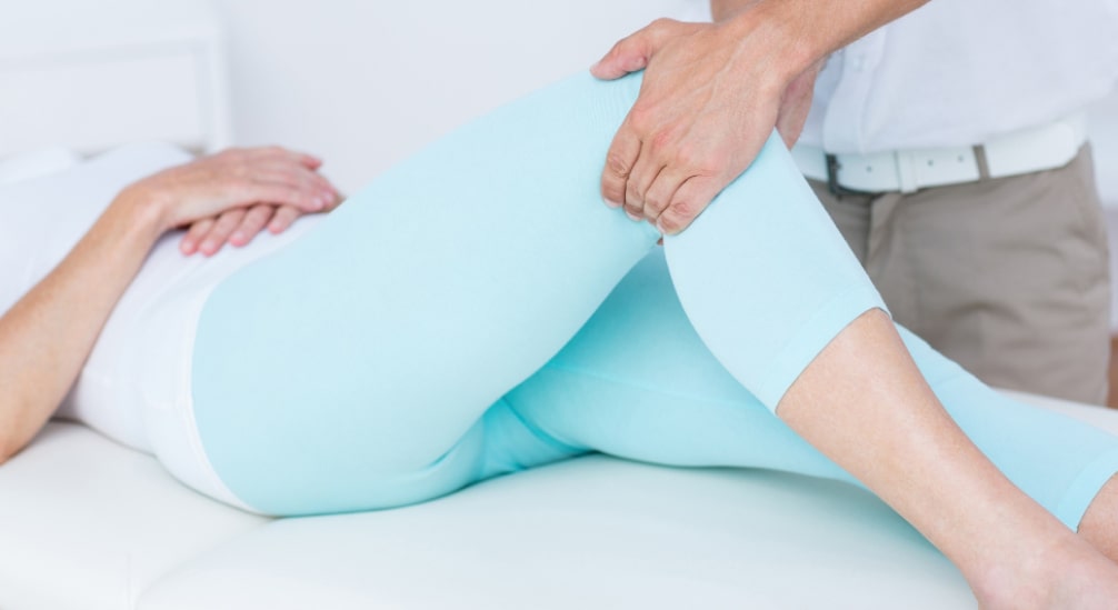 Fizjoterapeuta rehabilituje nogę pacjentki