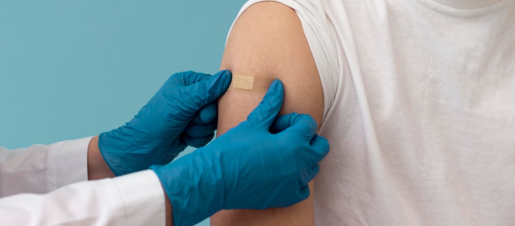 Lekarz nakleja plaster na rękę po szczepieniu